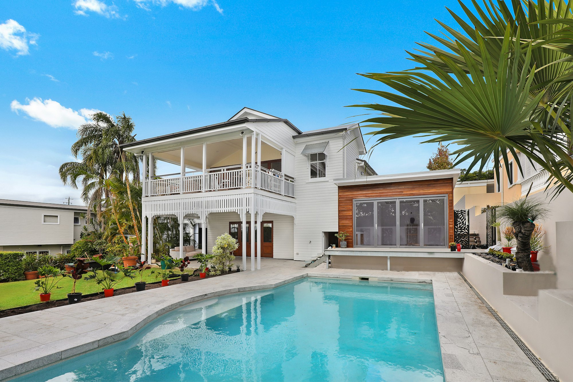 White South Florida home with a pool, patio, and palm trees